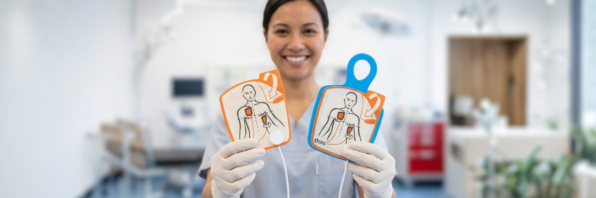 AED electrode pads applied to CPR manikin in correct antero-lateral placement during first aid training