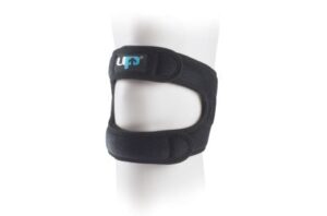 A black LP patellar knee strap worn around the leg, featuring adjustable Velcro straps and an open kneecap design to provide targeted support for runner’s knee and patellar tendon pain.