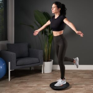 Woman standing on one leg on a rotating balance board during a training exercise at trimbio
