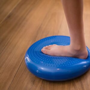 Bare foot balancing on a wobble cushion during a single-leg exercise at trimbio UK
